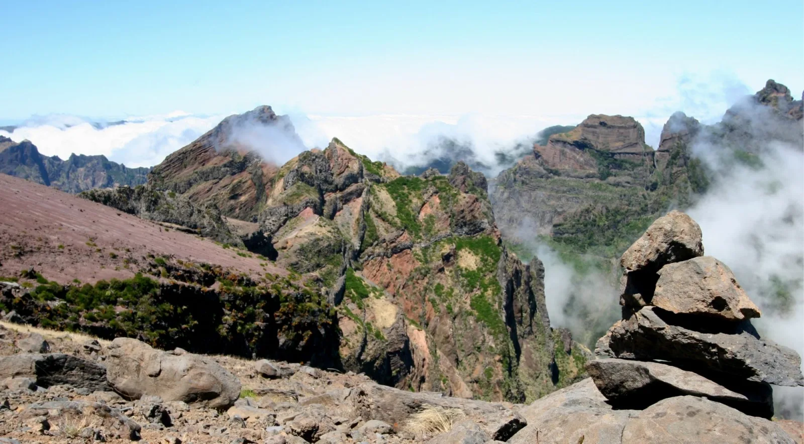 Red volcanic pinnacles of Pico do Arieiro standing above the cloud