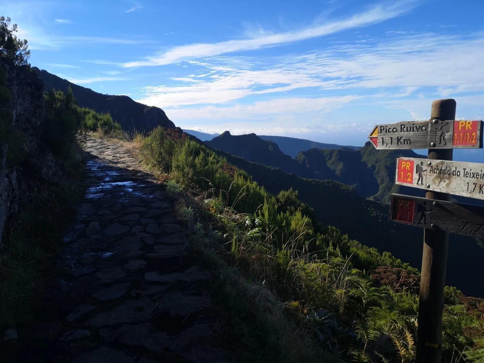A trail signpost on the Pico Ruivo path with the stone-paved route ahead