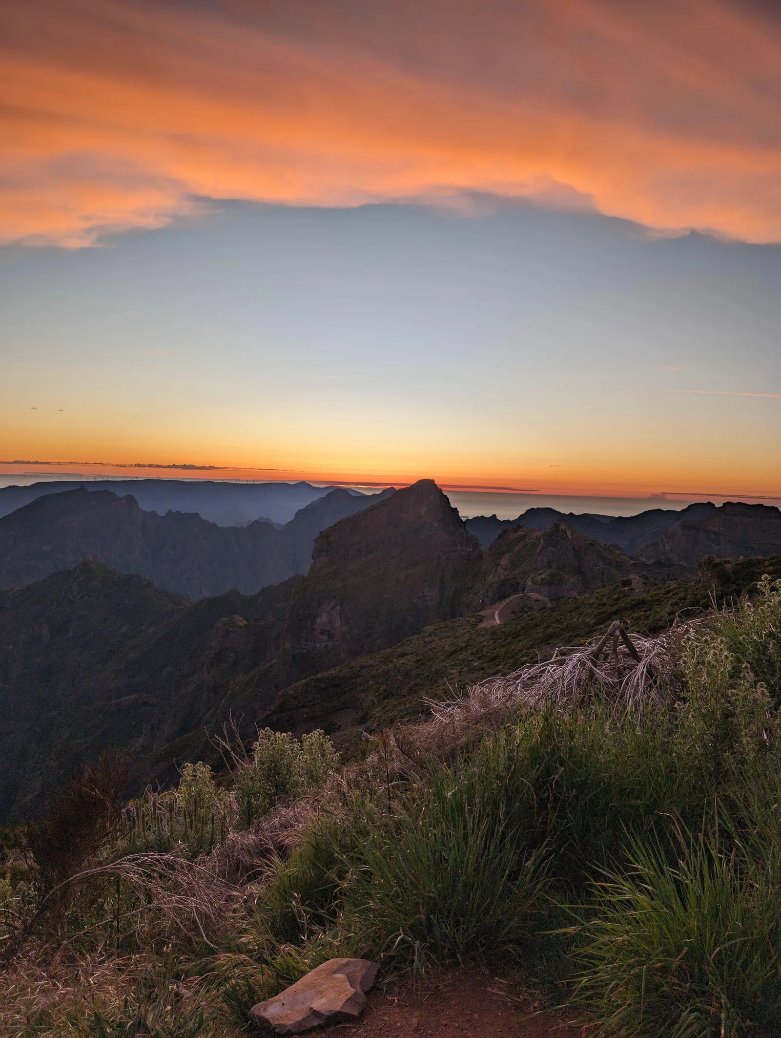 Pink and orange cloud banks above the mountains after sunset