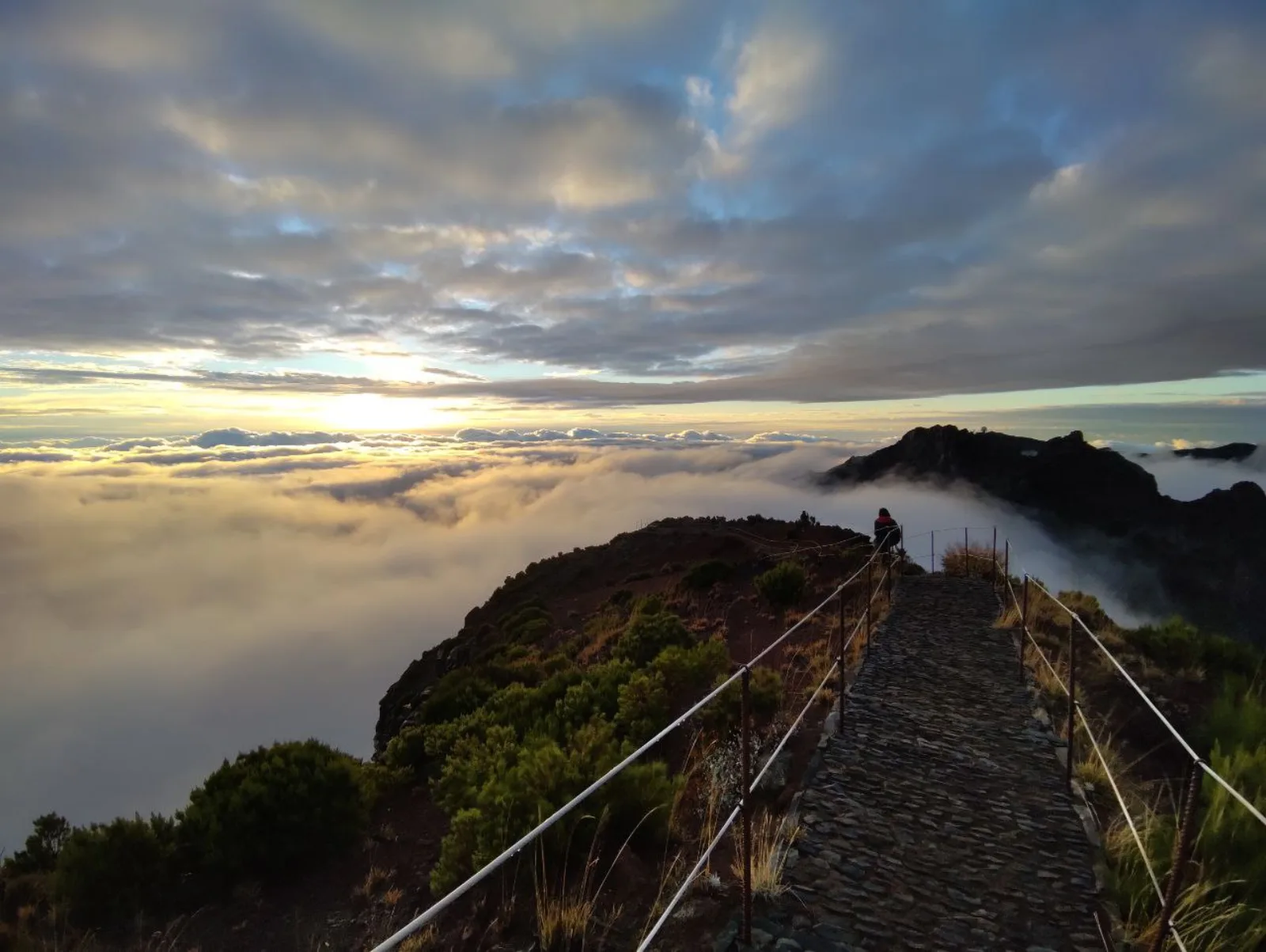 The stone summit path above the cloud layer in the first light of day