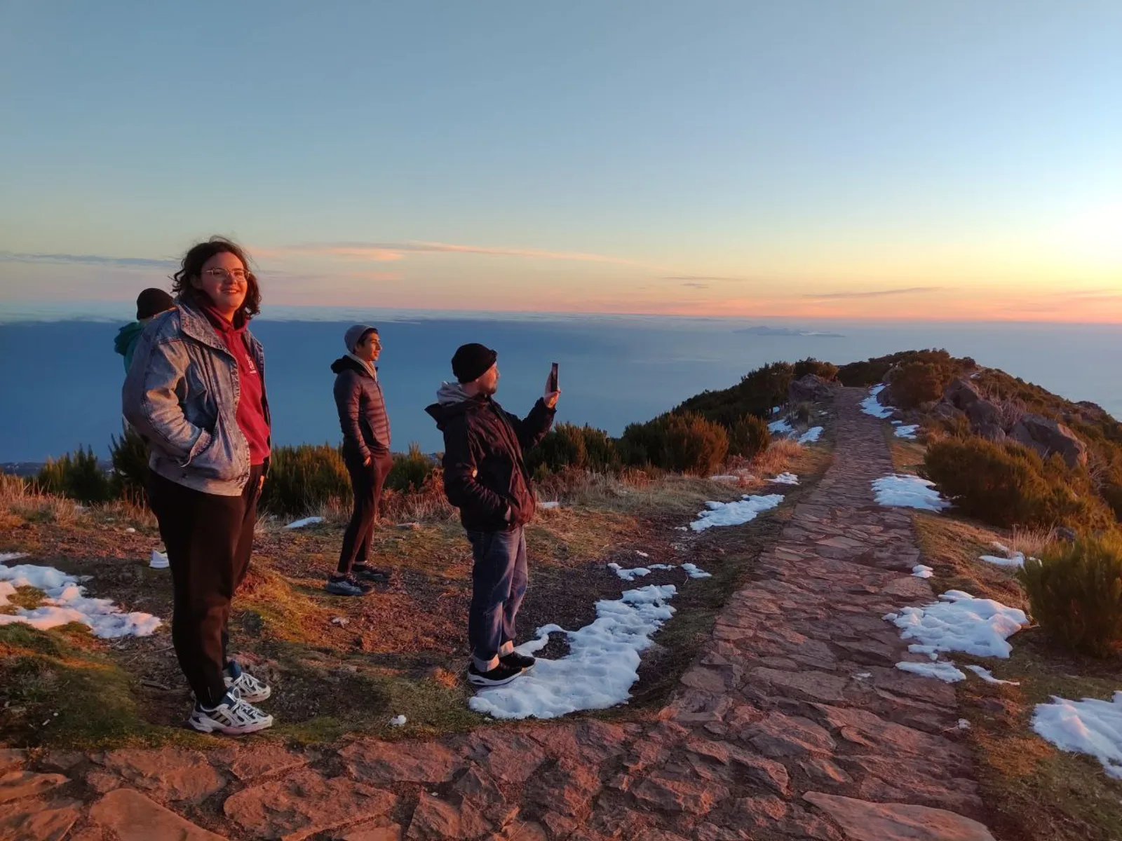 The guided group at the summit at first light, with snow patches beside the path